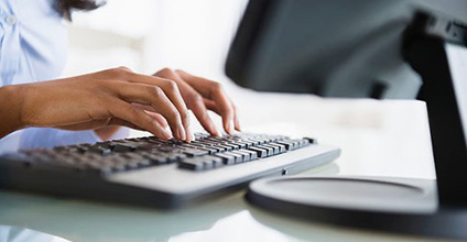 Image of a woman's hands typing on a keyboard