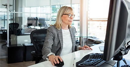 Image of a professional woman using a desktop computer